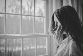 grieving womam at window